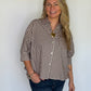 Brown gingham puff sleeve shirt with button front and split crew neckline worn by a woman.